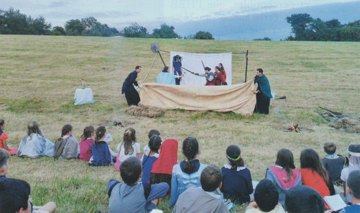 enfants regardant une pièce de théatre à la campagne