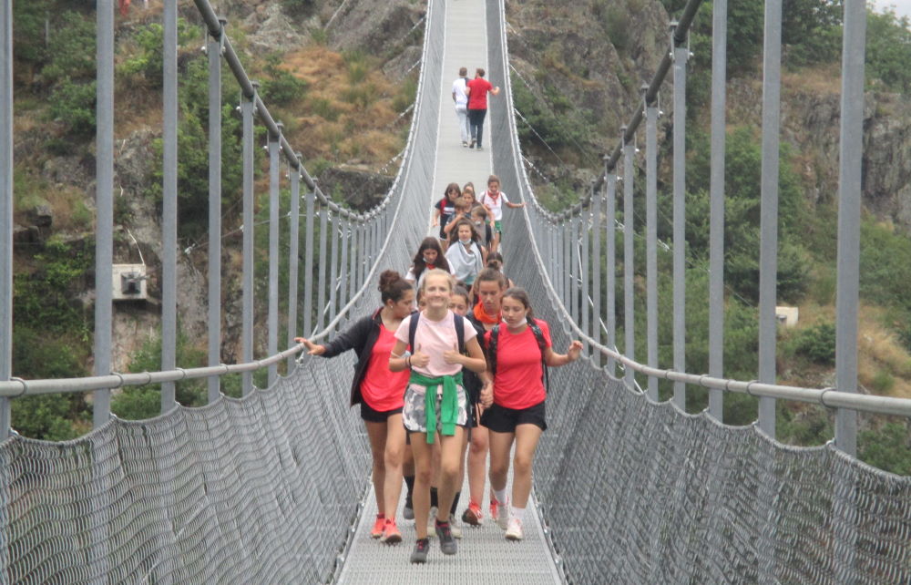 groupe de jeunes marchant sur une longue passerelle