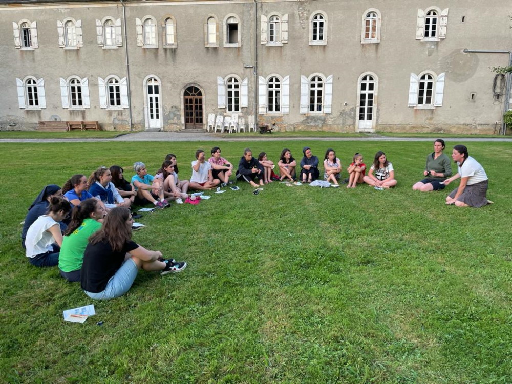 groupe de jeunes filles assises en cercle dans un pré