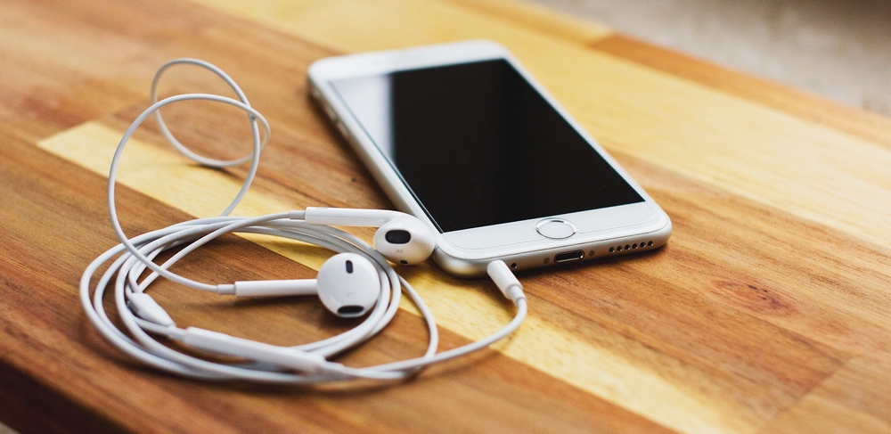 un smarthone et des écouteurs audio sur une table